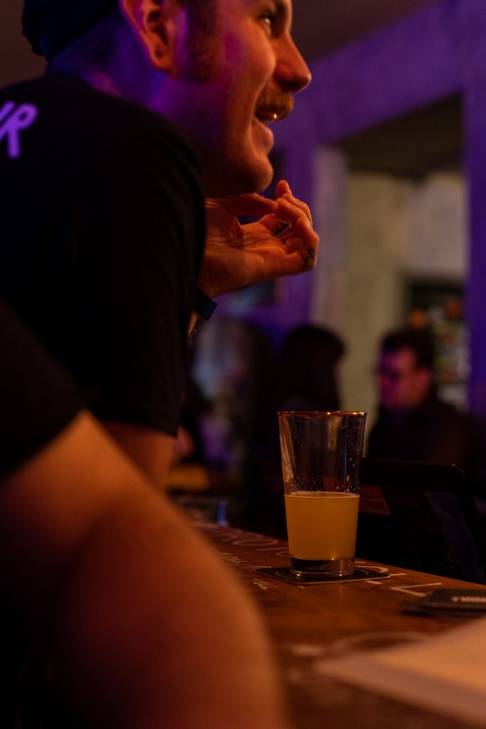 Customer at the bar at Vadim opens a bottle of Wilde Bosbessen from Guezestekerij de Cam at the 2nd Protokoll Birthday celebrations at Protokoll Taproom Berlin